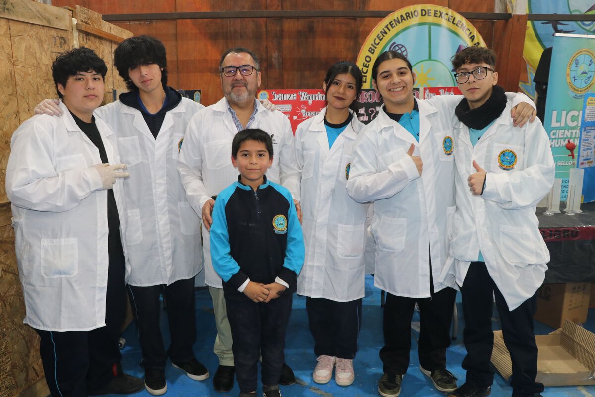 Estudiantes junto a sus paneles de investigación en el gimnasio